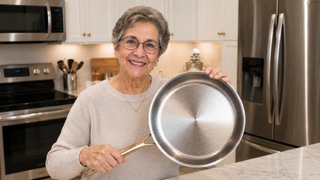 Home cook holding a Taima titanium frying pan in a kitchen